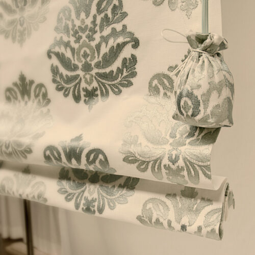 Besticktes Faltrollo mit dekorativen Sylter Säckchen als stilvollen Akzent.