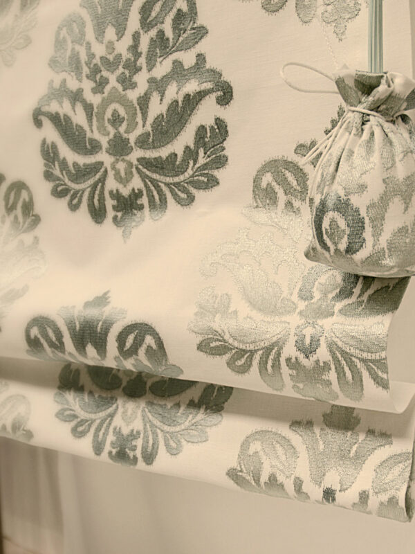 Besticktes Faltrollo mit dekorativen Sylter Säckchen als stilvollen Akzent.