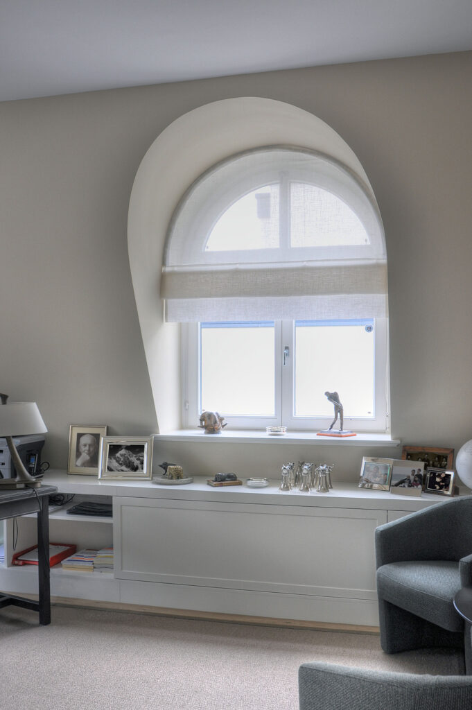 Maßgefertigtes Biesenfaltrollo für ein Rundbogenfenster, stilvolle Fensterdekoration mit lichtdurchlässigem Stoff.