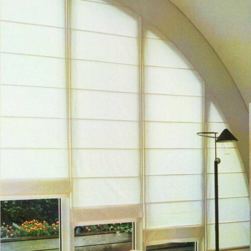 Maßgefertigte Biesenfaltrollos für Rundbogenfenster, stilvolle Fensterdekoration mit sanftem Lichteinfall.