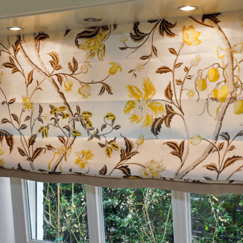 Faltrollo mit floralem Muster, u-förmiger Einfassung, sichtbarem unteren Rand und Dimout-Futter für besseren Lichtschutz.