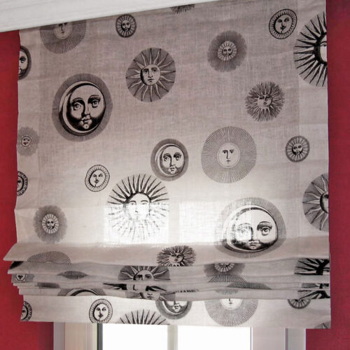 Classic Faltrollo mit senkrecht aufgenähten Schlaufenbändern und geradem Abschluss, gefertigt aus transparentem Stoff mit dekorativem Sonnenmotiv.