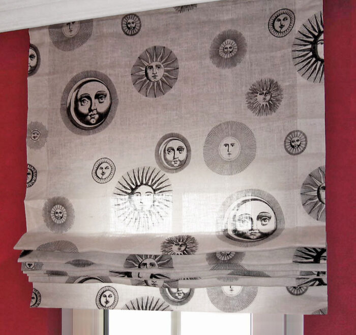 Classic Faltrollo mit senkrecht aufgenähten Schlaufenbändern und geradem Abschluss, gefertigt aus transparentem Stoff mit dekorativem Sonnenmotiv.