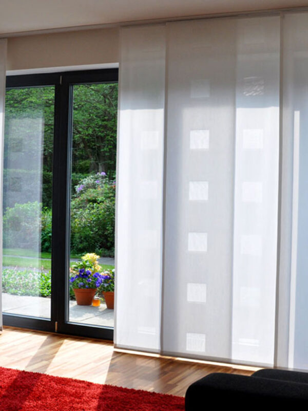 Moderne Flächenvorhänge aus weißem Ausbrenner-Stoff vor einer großen Fensterfront.