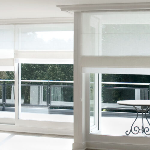 Präzise gearbeitete Biesenfaltrollos aus Leinen mit Stäben auf gleicher Höhe und elegantem Schabrackenabschluss.