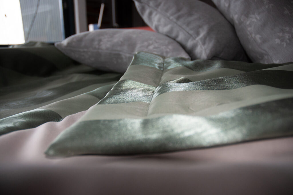 Leicht wattierte Tagesdecke mit abgestepptem Saum in edlem Streifendesign.