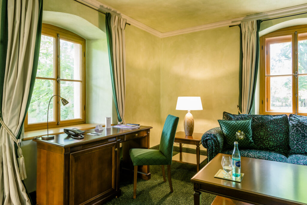 Elegantes Schlosshotel-Zimmer mit opulenten Vorhängen und stilvoller Einrichtung.