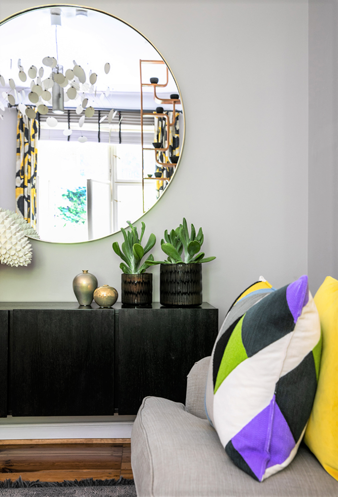 Modernes Wohnzimmer mit dekorativen Kissen mit Mini-Stehsaum in kräftigen Farben und geometrischem Muster.