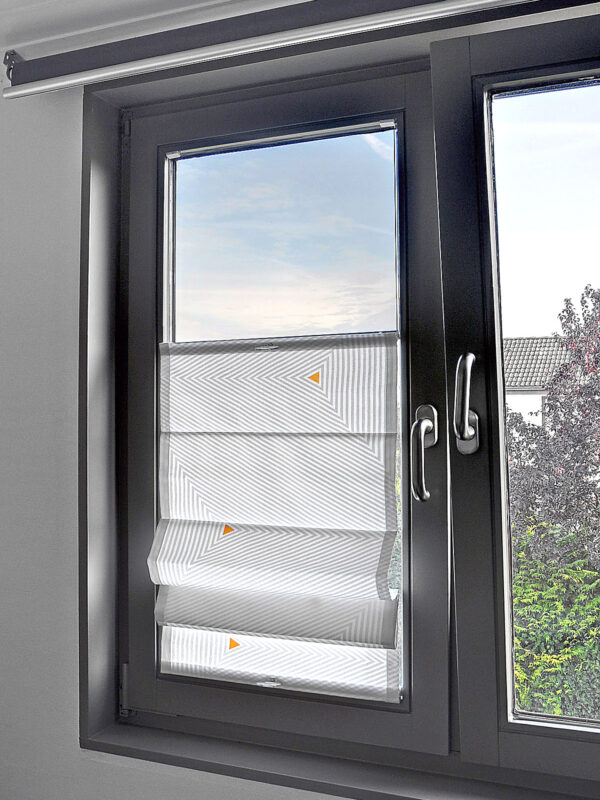 Faltrollo zum Verschieben mit geometrischem Muster in Grau und kleinen farblichen Akzenten, montiert an einem modernen Fenster mit dunklem Rahmen.